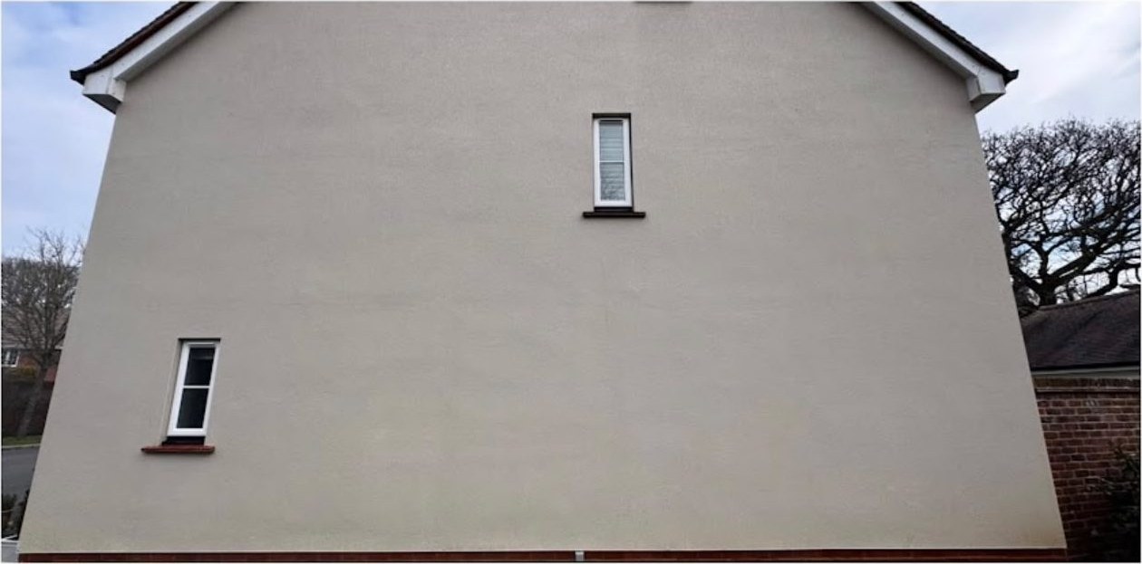 Red algae streaks removed from a rendered gable wall, before and after in Lymington - after