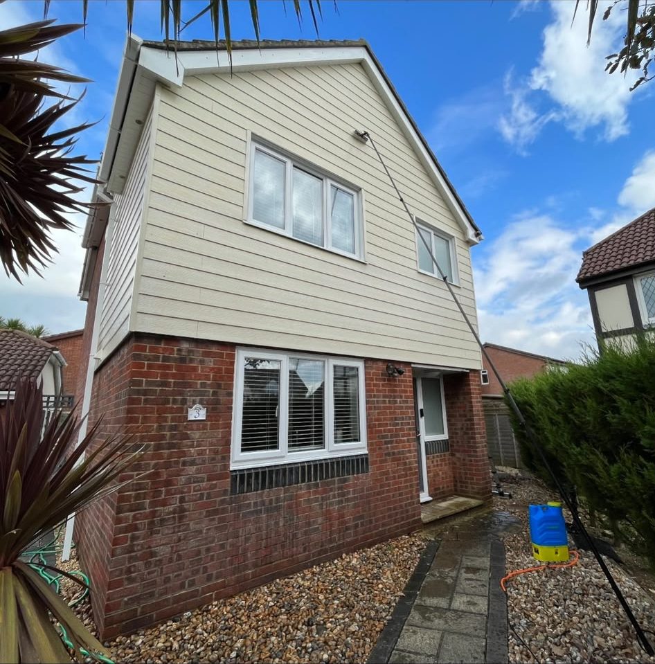 Reach-and-wash pole cleaning first-floor windows and cladding in Lymington