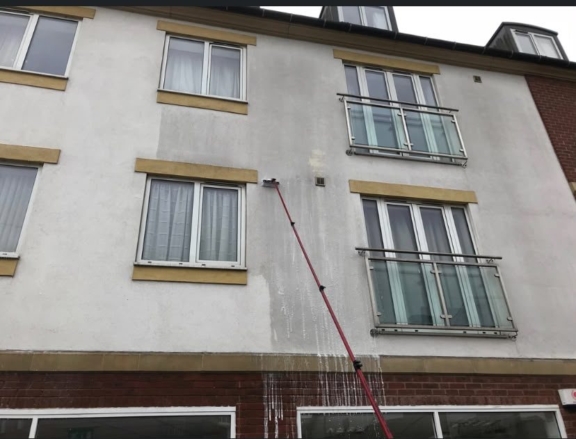 Water-fed pole cleaning the upper floors of a three-storey building in Lymington