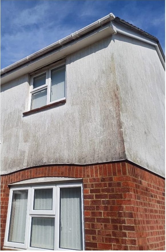 Render cleaning before and after on a two-storey home in Lymington - before
