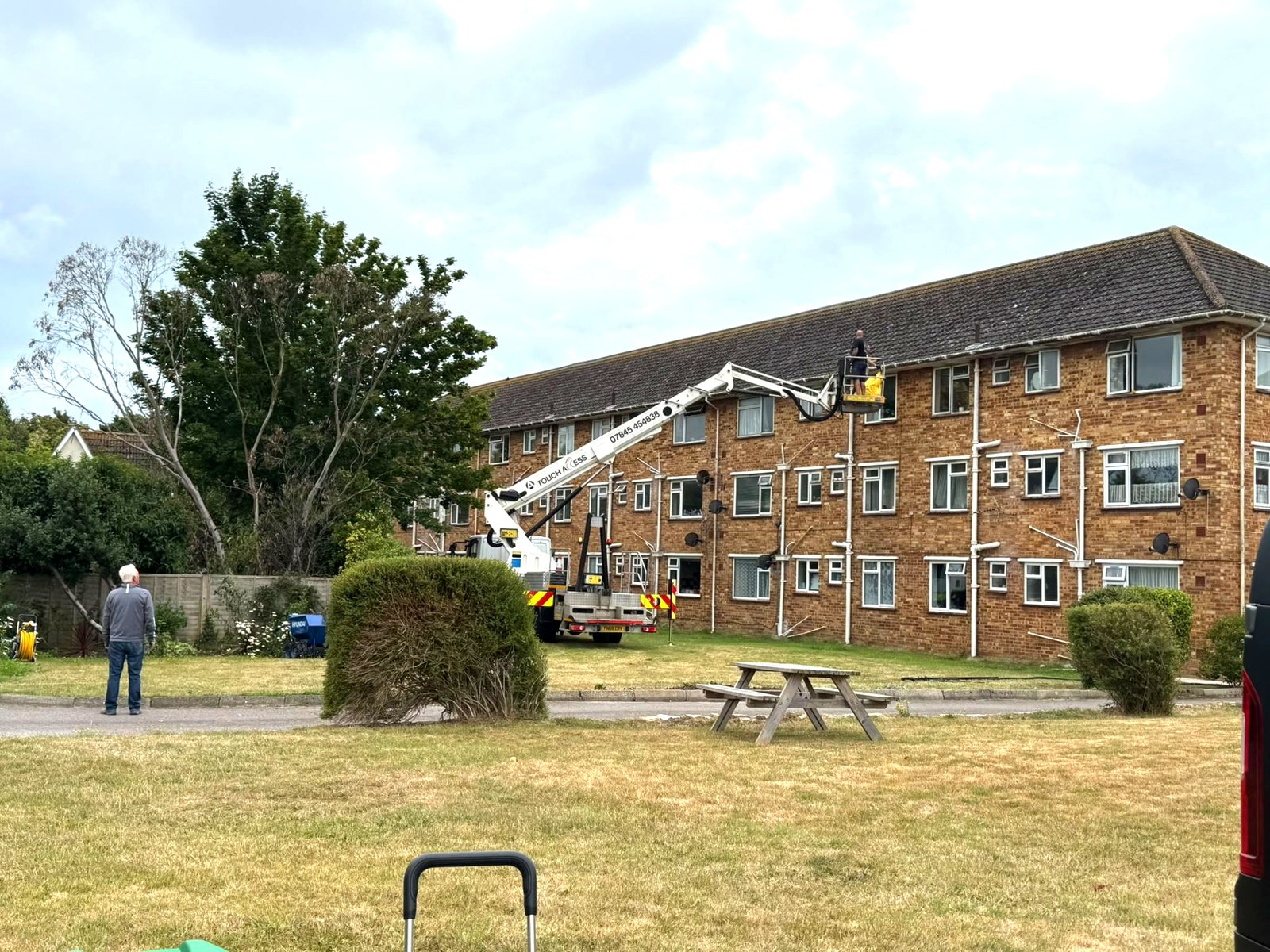 Cherry picker used for high-level gutter and fascia cleaning on a three-storey block in Lymington