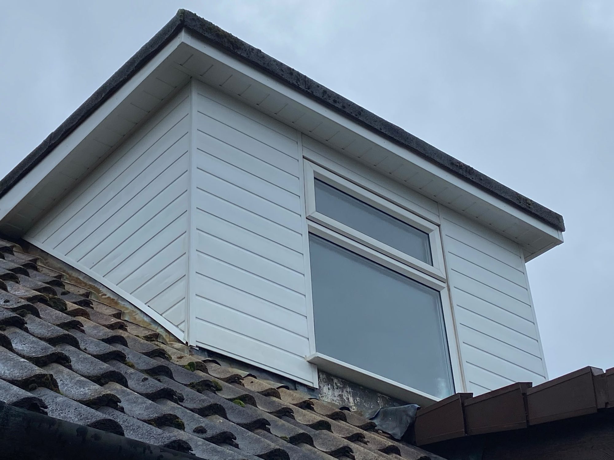 Clean white UPVC cladding on a dormer after soft washing in Lymington