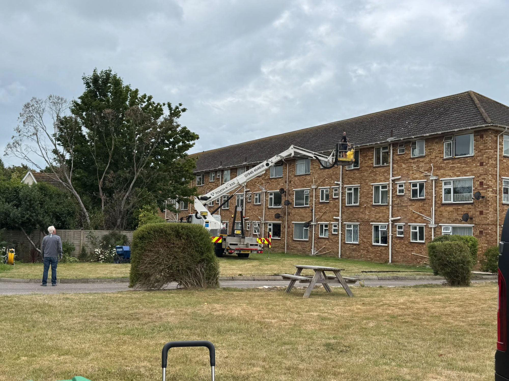 Cherry picker high-level cleaning beside a multi-storey building in Lymington